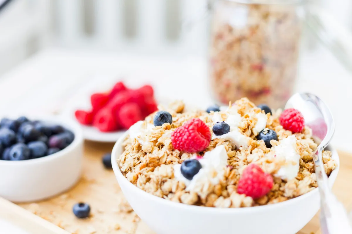 Mains tenant un paquet de granola et lisant la liste des ingrédients et le tableau nutritionnel au dos de l'emballage