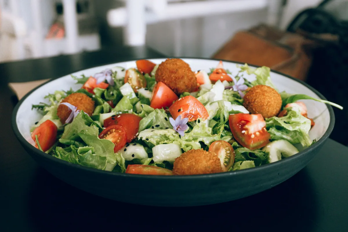 Salade composée dressée avec amandes torréfiées, abricots secs en lanières et pousses de roquette